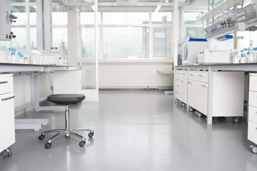 Tabouret LABSIT à roulettes au milieu d’un laboratoire entre deux rangées de paillasses